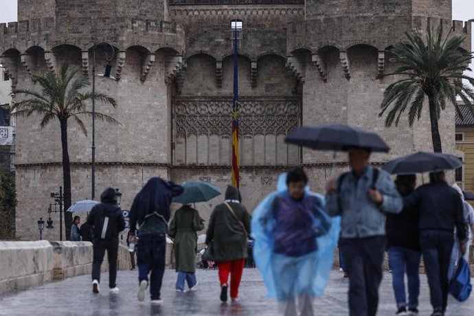Pessoas com guarda-chuvas caminham em 9 de outubro de 2025 em Valência, Valência (Espanha). A Agência Estatal de Meteorologia (AEMET) ativou o alerta laranja para chuvas em Valência, o que forçou a prefeitura a suspender o