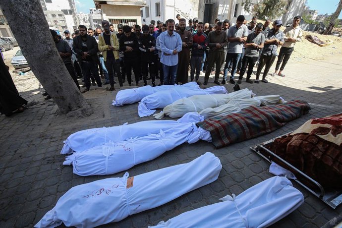 Archivo - Arquivo - Palestinos rezam ao lado dos corpos de várias pessoas mortas em ataques do exército israelense à Cidade de Gaza, no norte da Faixa de Gaza (arquivo).