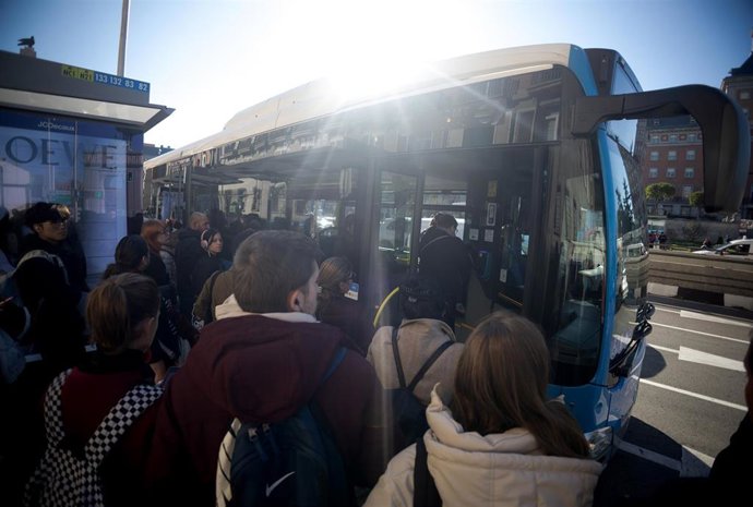 Archivo - Varias personas esperan al autobús.