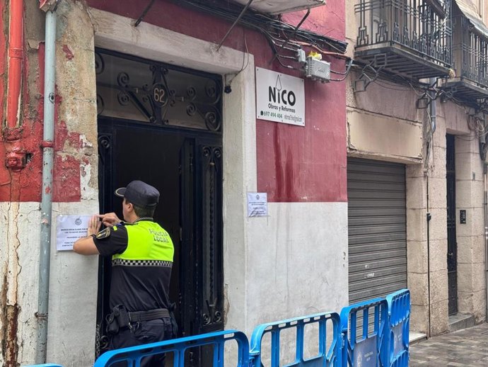 Un agente de la Policía Local de Alcoi (Alicante) precinta el edificio afectado