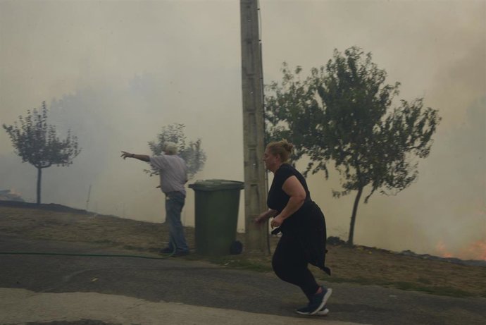 Dos vecinos colaboran en la extinción del fuego, en las proximidades de O Bolo, en Ourense