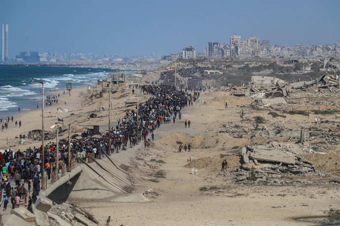 10 de outubro de 2025, Nusairat, Faixa de Gaza, Território Palestino: Palestinos caminham pela estrada Al-Rashid em direção à Cidade de Gaza a partir de Nuseirat, no centro da Faixa de Gaza, em 10 de outubro de 2025. As forças israelenses declararam um ce