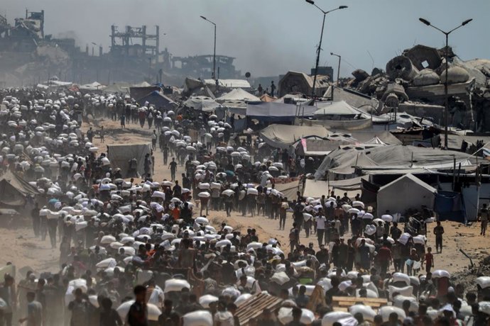 GAZA, Oct. 8, 2025  -- Palestinians fetch humanitarian aid that entered Gaza through a border crossing, in Beit Lahia, northern Gaza Strip, on July 27, 2025. As Hamas and Israel are meeting in Egypt over a potential ceasefire the world anxiously awaits, G