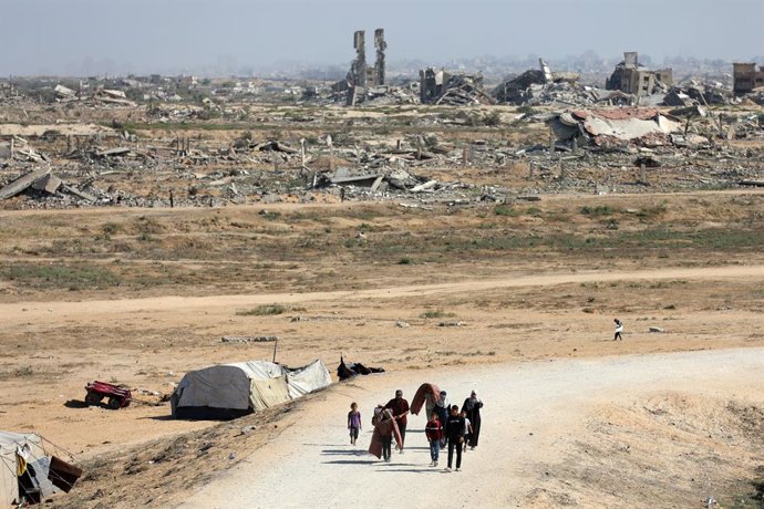 CIDADE DE GAZA, 10 de outubro de 2025 -- Palestinos caminham na estrada que retorna à Cidade de Gaza, perto do centro da Faixa de Gaza, em 10 de outubro de 2025. Os palestinos desalojados começaram a retornar da parte sul da Faixa de Gaza para o norte dep