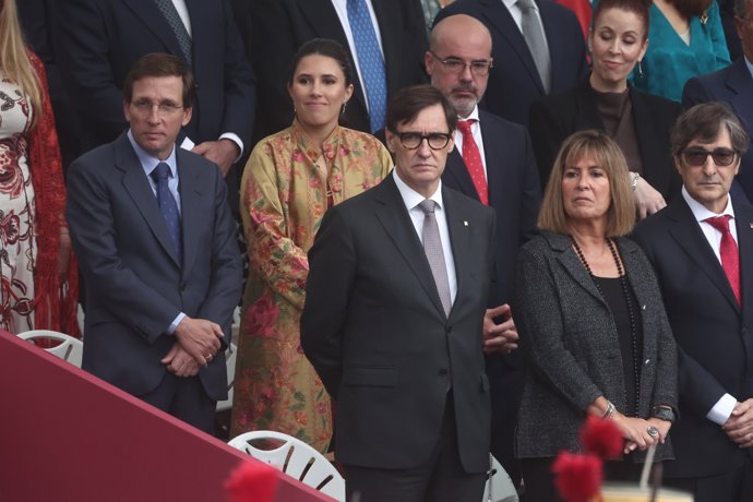 (I-D) El alcalde de Madrid, José Luis Martínez-Almeida, su mujer Teresa Urquijo, el presidente de la Generalitat de Catalunya, Salvador Illa, y el delegado del Gobierno en Madrid, Francisco Martín, durante el acto solemne de homenaje a la bandera 
