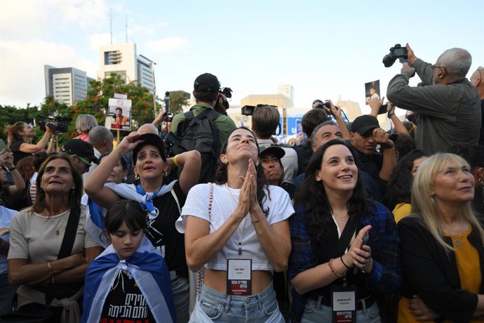 TEL AVIV, 13 de outubro de 2025 -- Pessoas assistem à transmissão ao vivo da libertação de reféns em uma praça em Tel Aviv, Israel, em 13 de outubro de 2025. Na manhã de segunda-feira, o Hamas começou a libertar o primeiro lote de reféns que estavam preso