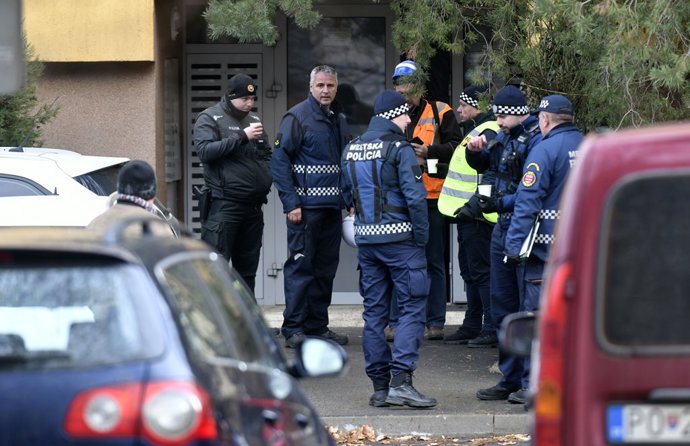 25 November 2022, Slovakia, Presov: Police officers stand at the entrance to an an apartment building after an overnight fire. Two people have died in a fire in a prefabricated high-rise building in Slovakia, the rescue services said on Friday.