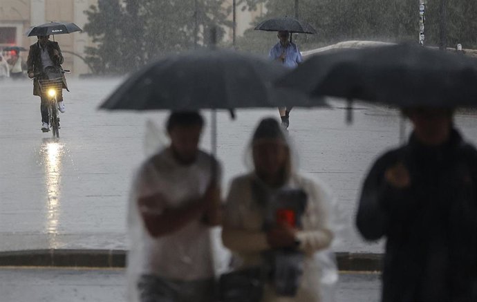 Archivo - Varias personas con paraguas bajo la lluvia, a 15 de septiembre de 2023, en València