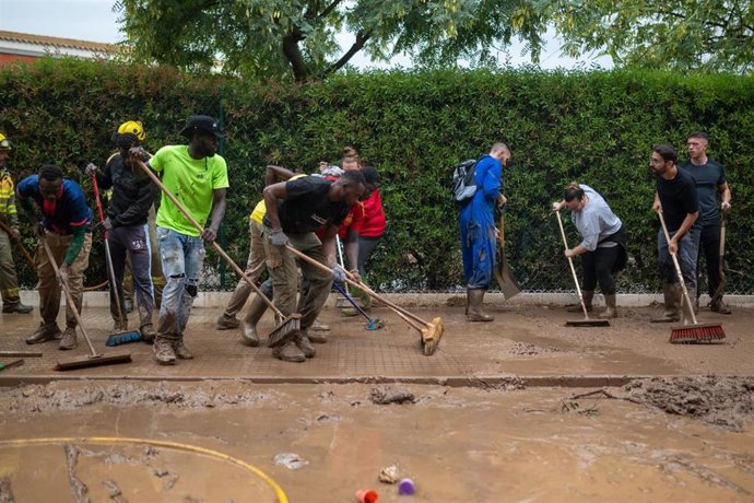 Vecinos de La Ràpita (Tarragona) limpian el barro de una de las calles afectadas por el temporal
