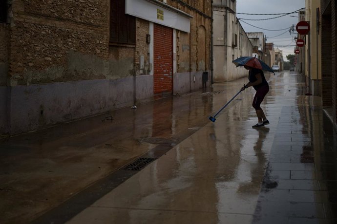 Veïns netegen el fang dels carrers, a 13 d'octubre del 2025, a Santa Bàrbara, Tarragona