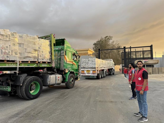 SHARM EL-SHEIKH, Oct. 12, 2025  -- Staff members from Egyptian Red Crescent stand near the trucks carrying humanitarian aids as they enter Gaza from the Egyptian side of the Rafah border crossing on Oct. 12, 2025. Egyptian President Abdel Fattah al-Sisi s