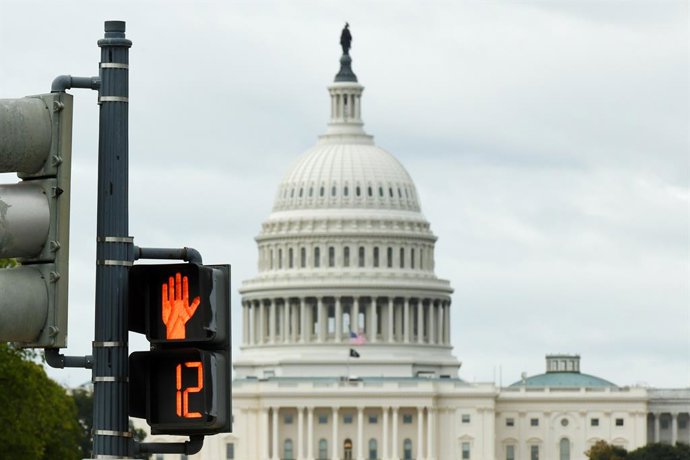 WASHINGTON, 13 de outubro de 2025 -- Esta foto tirada em 12 de outubro de 2025 mostra o edifício do Capitólio dos EUA atrás de um semáforo em Washington, D.C., Estados Unidos. A paralisação do governo federal entrou em seu 12º dia.