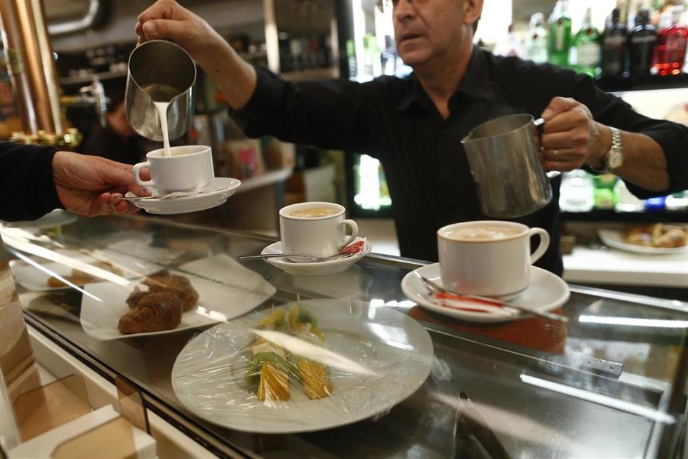 Archivo - Camarero poniendo cafés en un bar
