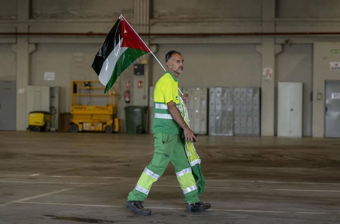 Trabajador con bandera palestina durante un paro parcial con motivo de la huelga general por Palestina, en la Empresa Municipal de Servicios Rivamadrid, a 15 de octubre de 2025, en Rivas Vaciamadrid, Madrid (España). Hoy está convocada una huelga general 
