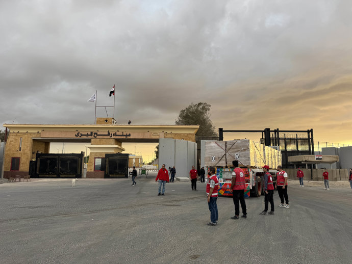 SHARM EL-SHEIKH, Oct. 12, 2025  -- Staff members from Egyptian Red Crescent stand near a truck carrying humanitarian aids as it enters Gaza from the Egyptian side of the Rafah border crossing on Oct. 12, 2025.