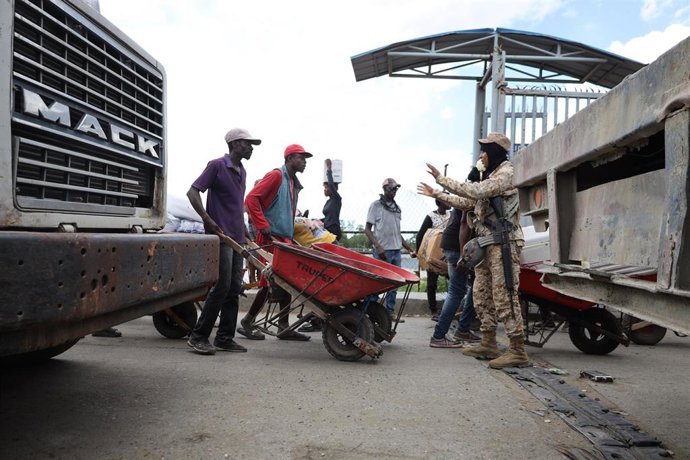 Archivo - Civiles haitianos esperan en la frontera con República Dominicana