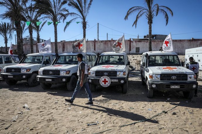 16 de outubro de 2025, Territórios Palestinos, Khan Yunis: Carros do Comitê Internacional da Cruz Vermelha (CICV) são estacionados enquanto os restos mortais dos palestinos que participaram do ataque de 7 de outubro são entregues por Israel. Os corpos for
