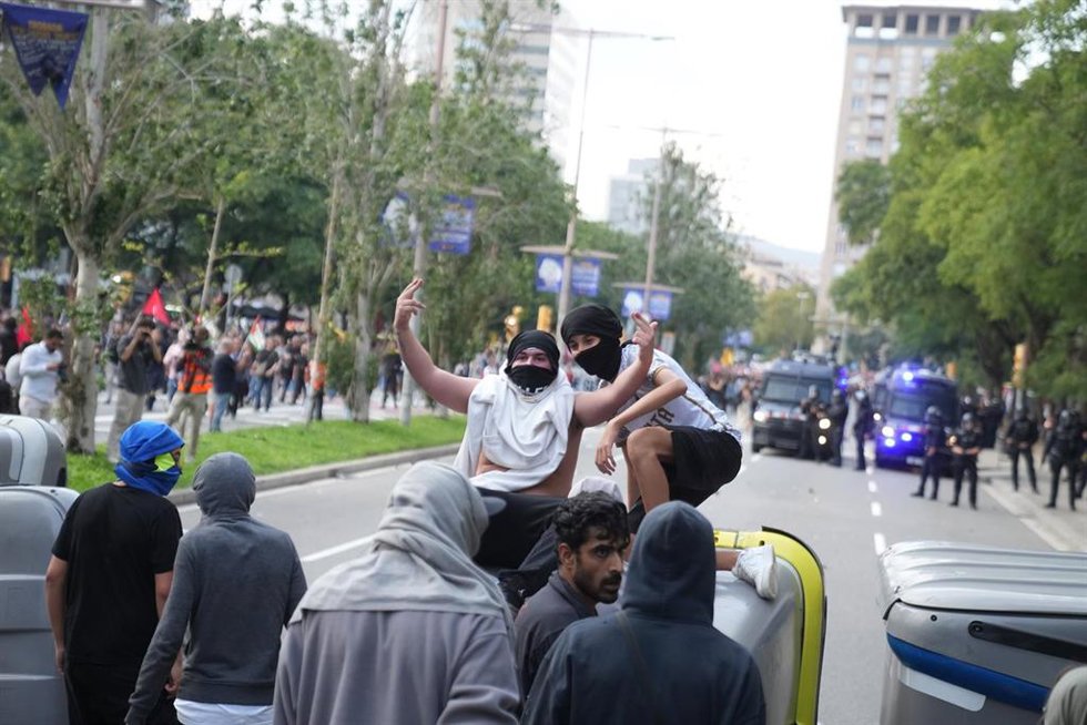 Varias personas encapuchadas hacen barricadas durante en una marcha unitaria de entidades propalestina.