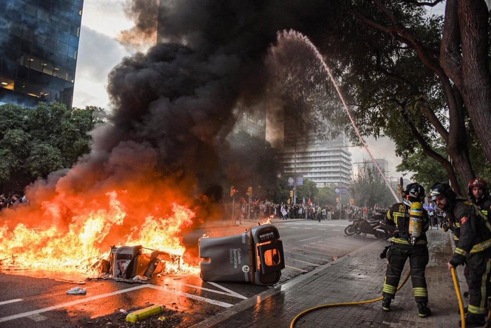 Los Bombers apagan contenedores incendiados durante la manifestación en favor de Palestina.