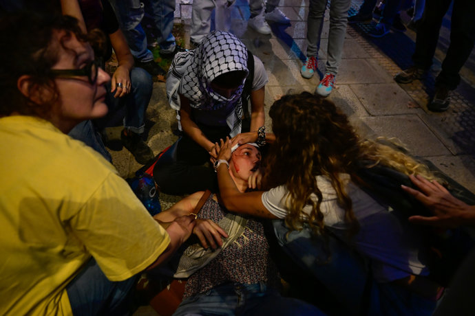Varias personas atienden a otra herida durante las movilizaciones por la celebración del partido de baloncesto entre el Valencia Basket y el Hapoel Tel Aviv israelí, frente al Roig Arena, a 16 de octubre de 2025, en Valencia, Comunidad Valenciana 