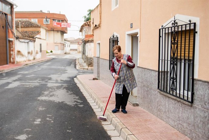 Archivo - Una vecina de la calle Murcia barre la entrada de su casa, a 28 de mayo de 2023, en Pozo Cañada, Albacete, Castilla-La Mancha (España). 