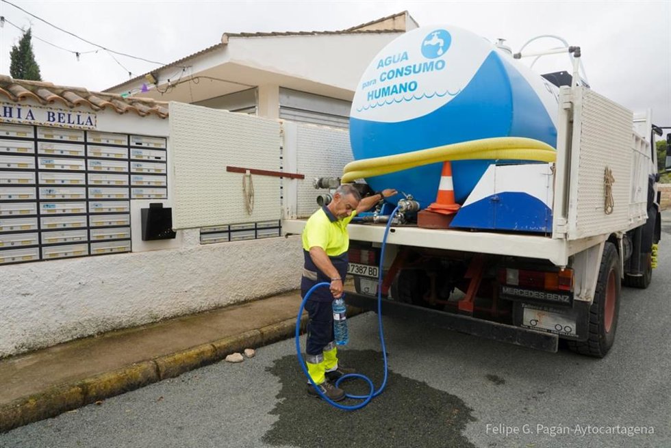 Un operario rellena una botella de agua potable de una cuba movil en Bahía Bella (Cartagena)
