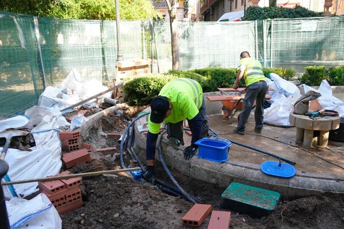 Operarios trabajan en la restauración de la fuente de los jardines de la plaza de la Reina de Palma.