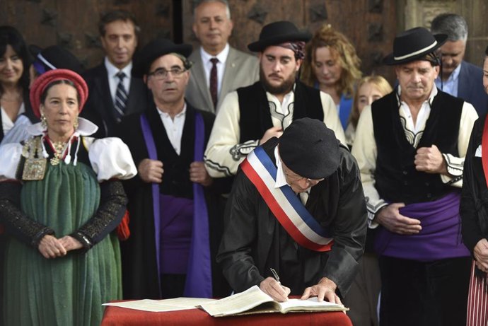 Varias personas recrean la frma del tratado durante el 650 aniversario del Tributo de las Tres Vacas, en el atrio de la Iglesia de San Pedro de Ansó (Huesca).