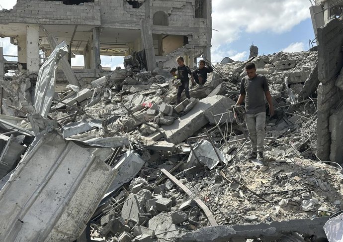 Palestinos nos escombros de vários prédios destruídos pelo exército israelense na cidade de Khan Younis, no sul da Faixa de Gaza (arquivo).