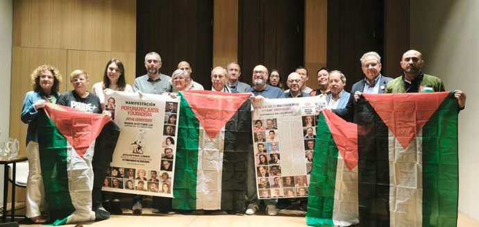 Miembros de la plataforma PararLaGuerra posan con banderas de Palestina en el Ateneo de Madrid.