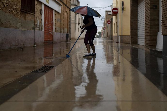 Vecinos limpian el barro de las calles, a 13 de octubre de 2025, en Santa Bárbara, Tarragona, Catalunya (España). 