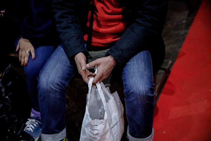 Archivo - Una mujer con una de las bolsas de comida preparadas por una ONG.