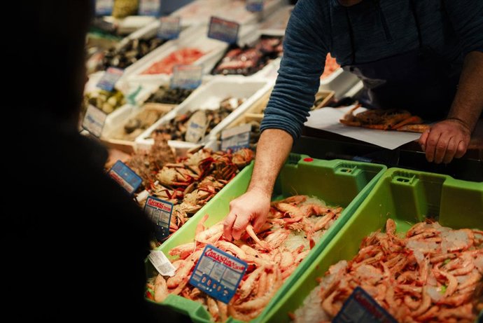 Archivo - Arxiu - Un botiguer servix llagostins a una dona