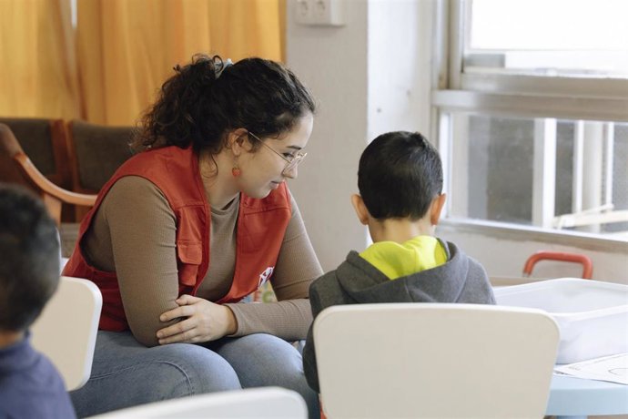 Educadora de CaixaProinfancia atendiendo niños en Save the Children.