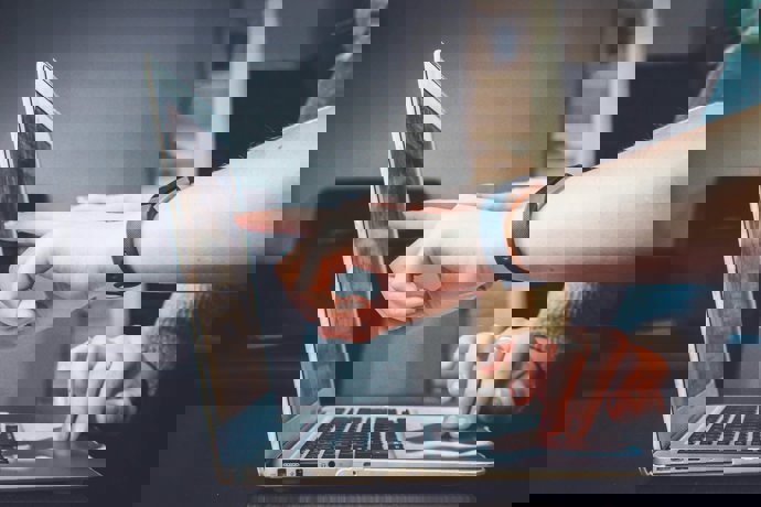 Persona delante de un ordenador portátil