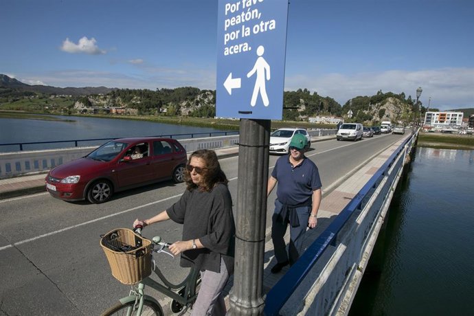 Archivo - Dos personas pasan por el puente de Ribadesella, antes del inicio de las obras de ampliación.