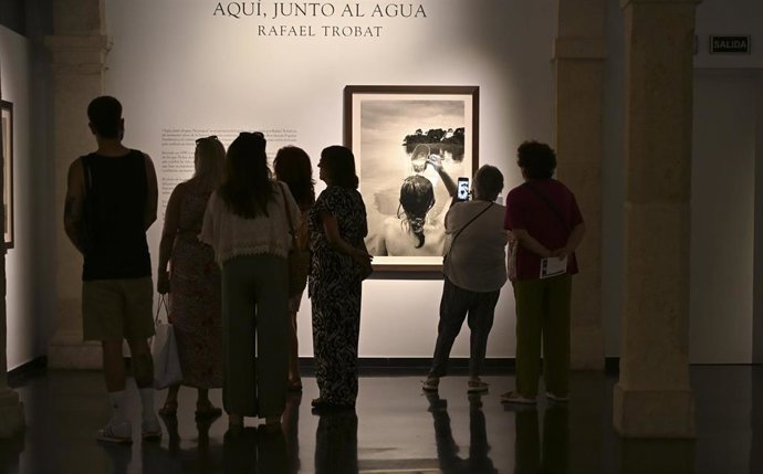 Archivo - Visitantes observan una fotografía expuesta en el CAF de Almería.