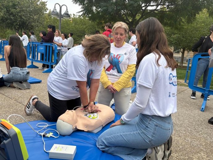 La gerente del 061, Marta Sampériz (al fondo) indica como se realiza una RCP, junto con la gerente del Sector II, Patricia Palazón, que muestra cómo se deben hacer las compresiones torácicas.
