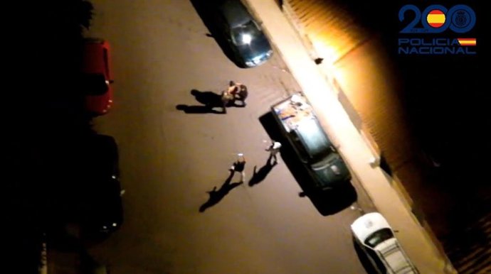 Agentes conducen al hombre a un vehículo policial tras su detención.