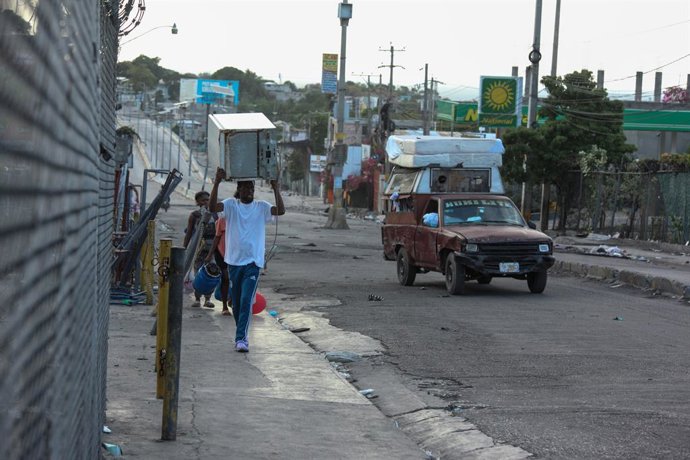 Archivo - Arquivo - 25 de fevereiro de 2025, Haiti, Porto Príncipe: Pessoas, carregando itens domésticos, fogem de suas casas durante mais um ataque de gangues em Porto Príncipe. Foto: Patrice Noel/ZUMA Press Wire/dpa