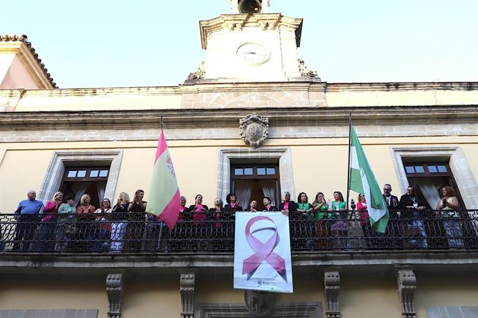 Colocación del lazo rosa por el cáncer de mama en el balcón del Ayuntamiento de Jerez de la Frontera (Cádiz)