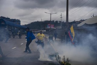 October 12, 2025, Quito, Pichincha, Ecuador: Protesters run away after police firing tear gas at them during the demonstration. Day 20 of the 2025 National Strike in Ecuador in discontent with the government of Daniel Noboa. The march was called as a peac