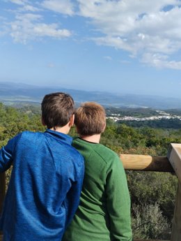 Dos menores contemplan la ciudad desde las alturas.