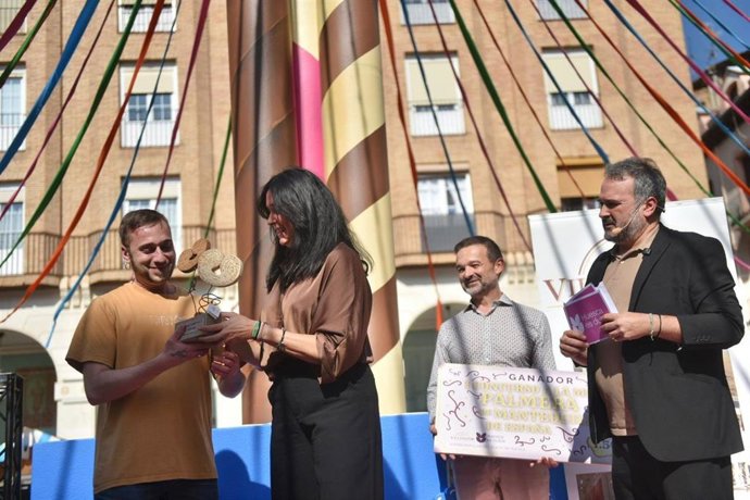 La alcaldesa de Huesca, Lorena Orduna, entrega el galardón del I Concurso a la Mejor Palmera de Mantequilla de España a Isidro Tolosana, de Pastelería Tolosana, en el acto celebrado este sábado en la plaza Luis López Allué.