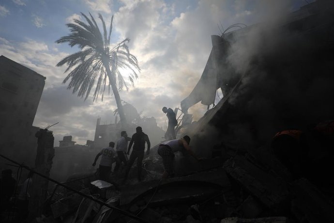 GAZA, 8 de outubro de 2025 -- Pessoas realizam trabalho de resgate em meio aos escombros de edifícios após um ataque aéreo israelense na cidade de Rafah, no sul da Faixa de Gaza, em 14 de dezembro de 2023. Enquanto o Hamas e Israel se reúnem no Egito para