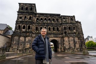 Santiago Posteguillo publica 'Los tres mundos', tercera parte de la saga de Julio César. El escritor visita los escenarios de la novela, como la ciudad de Tréveris, donde posa ante la Porta Nigra