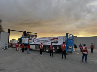 SHARM EL-SHEIKH, Oct. 12, 2025  -- Staff members from Egyptian Red Crescent stand near a truck carrying humanitarian aids as it enters Gaza from the Egyptian side of the Rafah border crossing on Oct. 12, 2025. Egyptian President Abdel Fattah al-Sisi said 