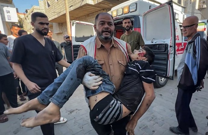 19 de outubro de 2025, Nusairat, Faixa de Gaza, Território Palestino: Palestinos carregam os corpos de duas pessoas e vários feridos para o Hospital Al-Awda no campo de refugiados de Nuseirat, no centro da Faixa de Gaza, após um ataque de drone israelense