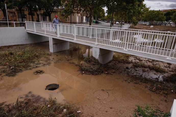Varias personas pasan por un puente del barranco de La Saleta, a 29 de septiembre de 2025, en Aldaia, Valencia, Comunidad Valenciana (España). 