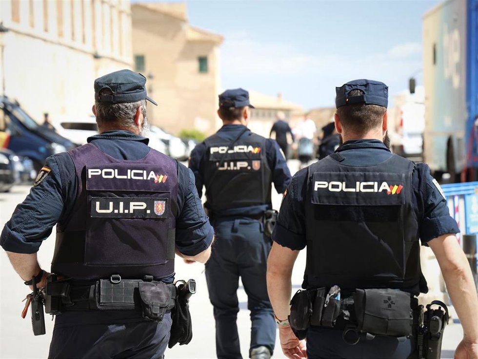 Archivo - Agentes de la Policía Nacional de espaldas.